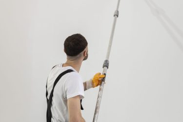 medium-shot-young-man-painting-wall